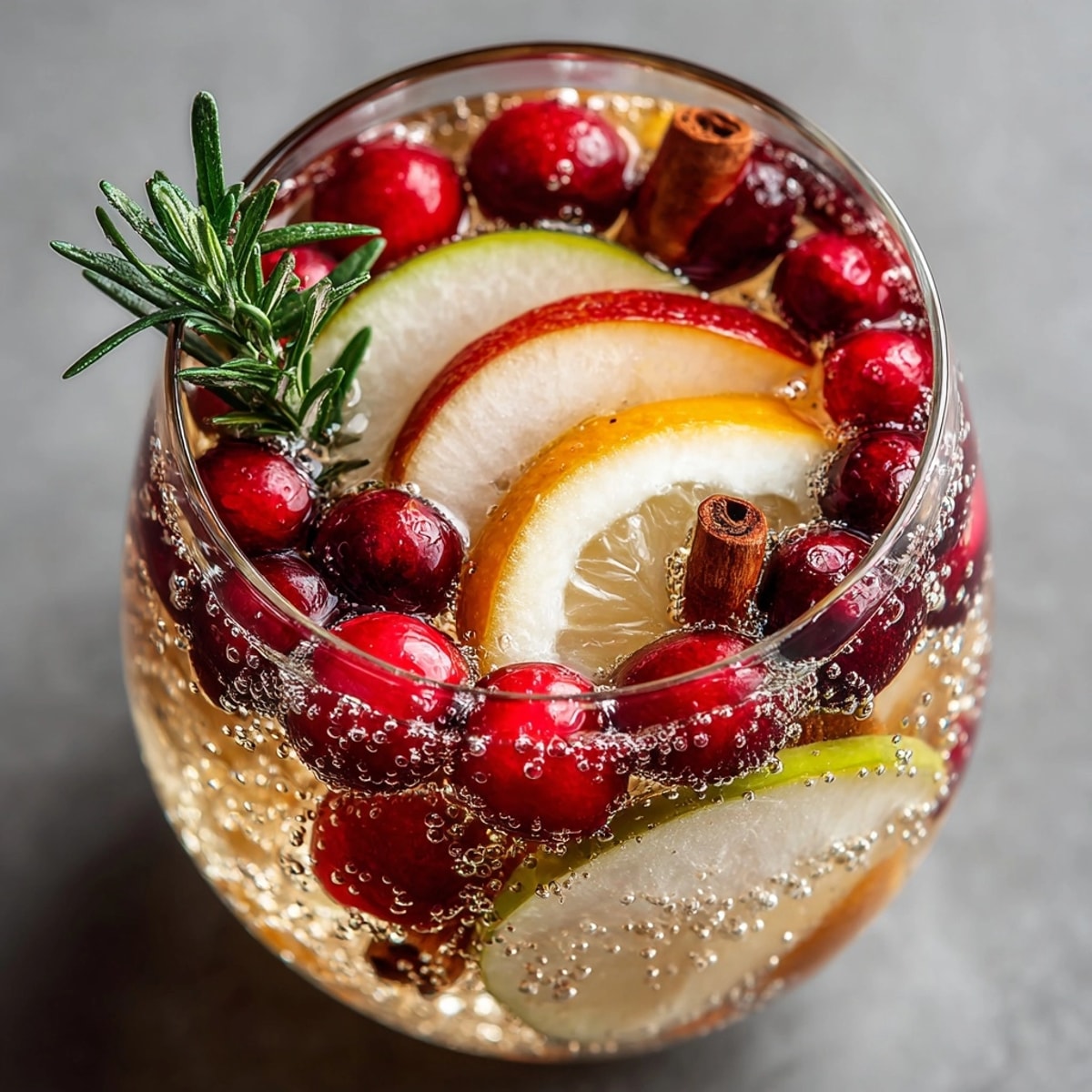 Festive Pear & Cranberry Sangria in a glass; ruby cranberries and citrus sparkling.