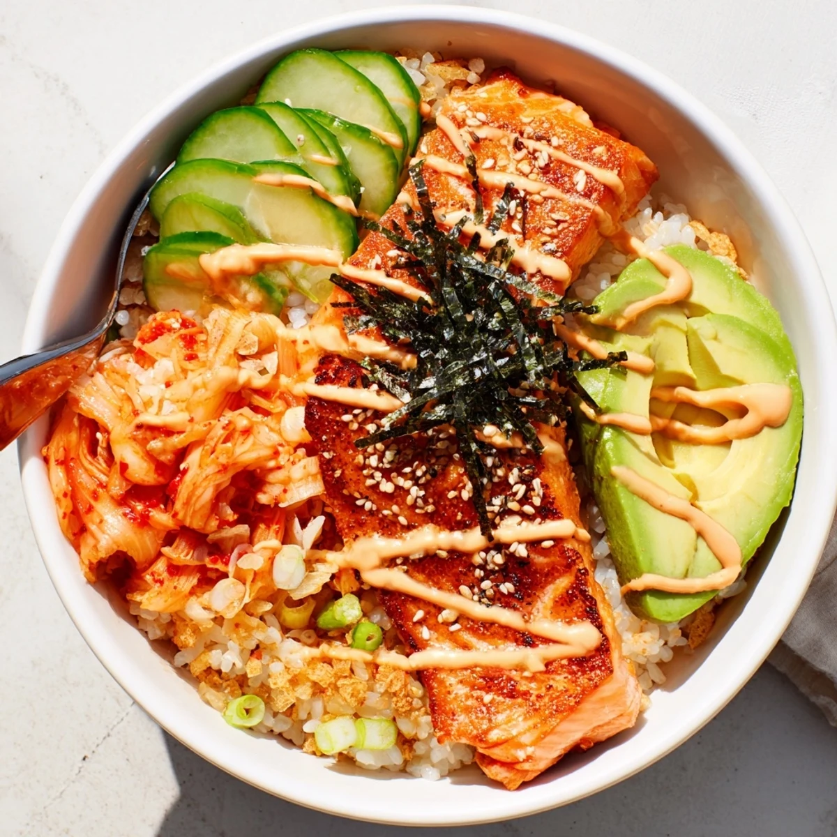 Crispy Salmon Rice Bowl garnished with fresh avocado and garlic, a flavorful delight.