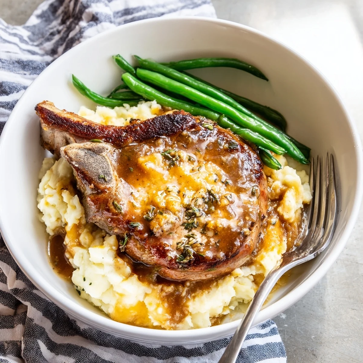 Comforting Pork Chops & Cheddar Mash Bowl with crisp green beans and rich flavors.  