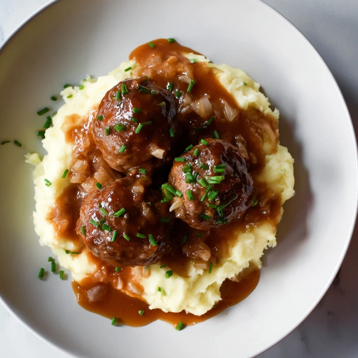 This image shows a comforting plate of BBQ Meatballs & Mashed Potatoes, steaming and ready to eat.