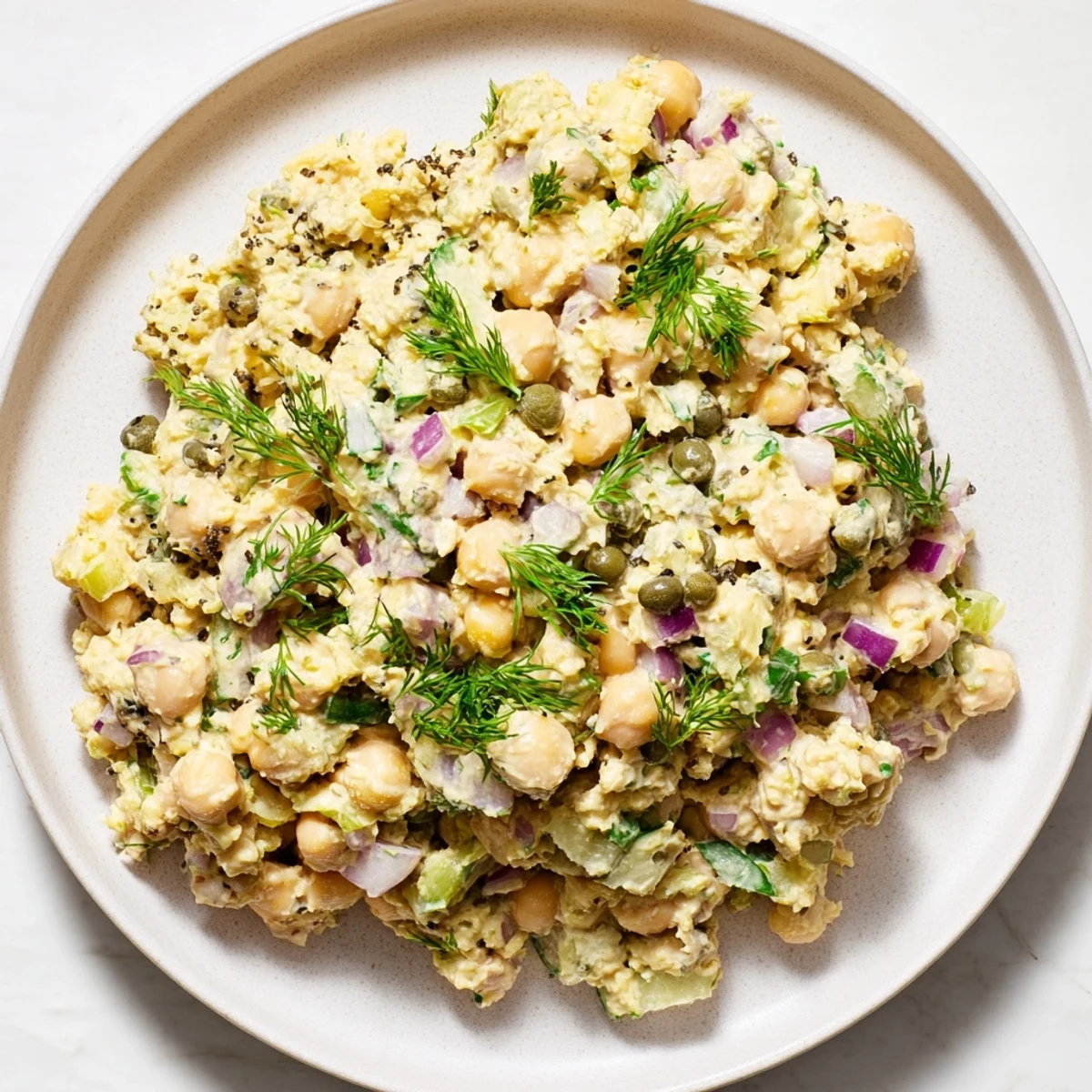 Mashed chickpea tuna salad, creamy and vibrant, served on whole grain bread, a vegan delight.
