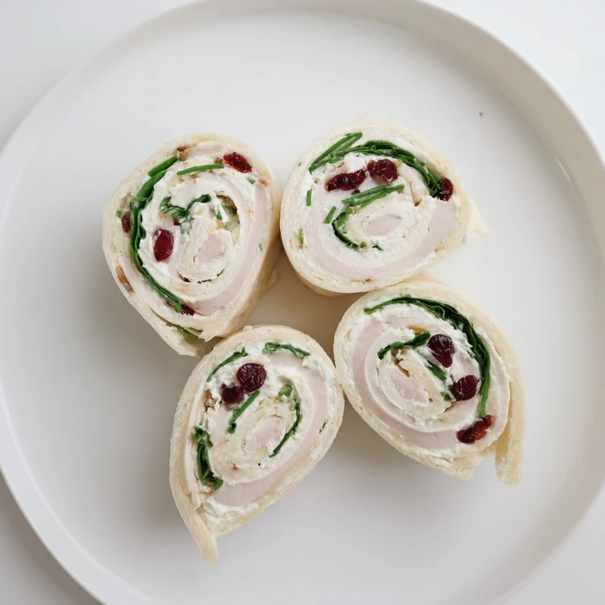 Close-up on a platter of delicious Turkey Cranberry Pinwheels with a vibrant blend of ingredients inside.