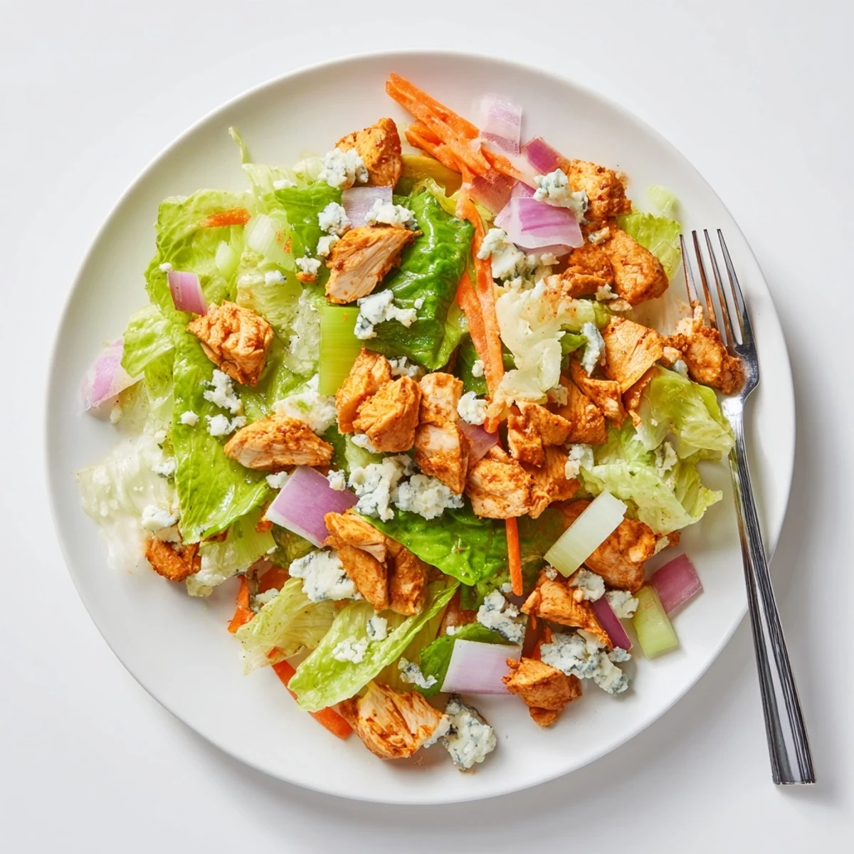 Freshly chopped romaine and juicy Buffalo Chicken Chopped Salad tossed with carrots and red onion, ready to enjoy.