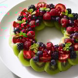 Fresh Kiwi and berry holiday wreath, featuring bright red strawberries nestled among the green kiwi and berries.