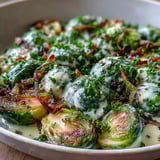 Golden-brown Brussels sprouts coated in a creamy cream cheese and Dijon mustard sauce, garnished with fresh parsley and served warm.