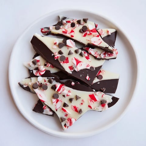 Dark and white chocolate Peppermint Bark shards, beautifully scattered on a wooden serving board.