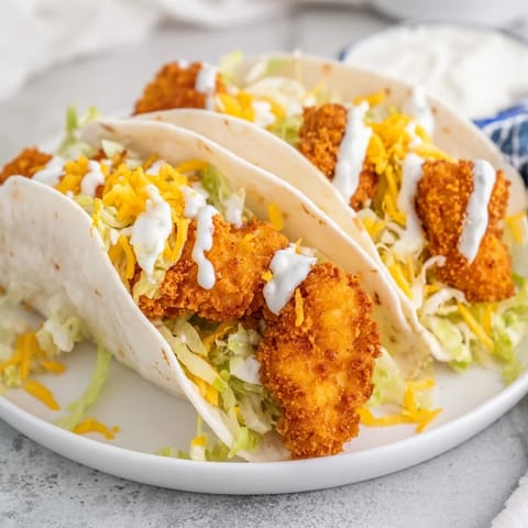 A close-up of a flavorful Crispy Chicken Ranch Snack Wrap showing juicy chicken and creamy ranch.