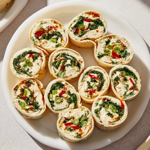 Vibrant Christmas Scarf Tortilla Roll-Ups with a cream cheese and veggie filling, perfect for any holiday gathering.