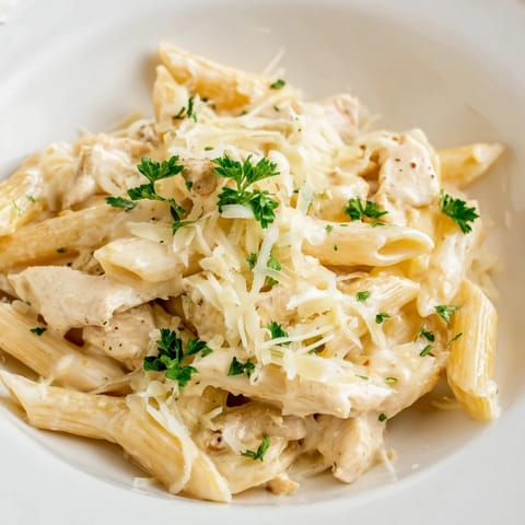 A close-up of a Chicken Alfredo Bake, showing the melted cheese and rich Alfredo sauce.