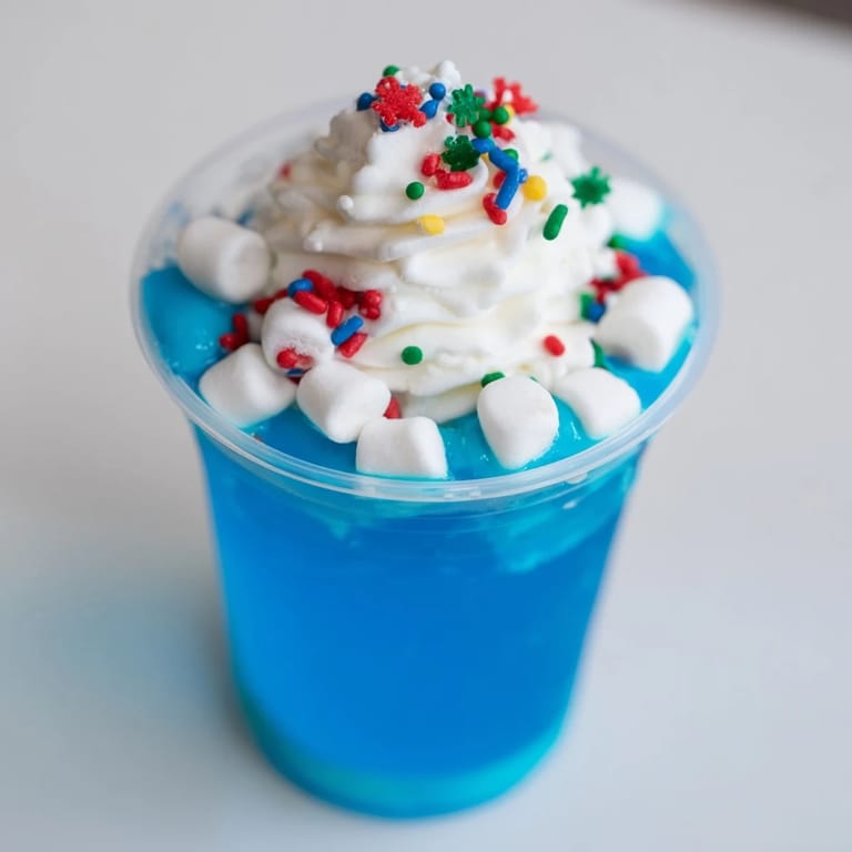 Layered snow globe Jello cups, a delightful dessert with jiggling blue gelatin, perfect for holidays.