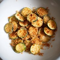 Golden-brown zucchini chips swap, crispy and tempting, ready to dip in marinara sauce for snack time.